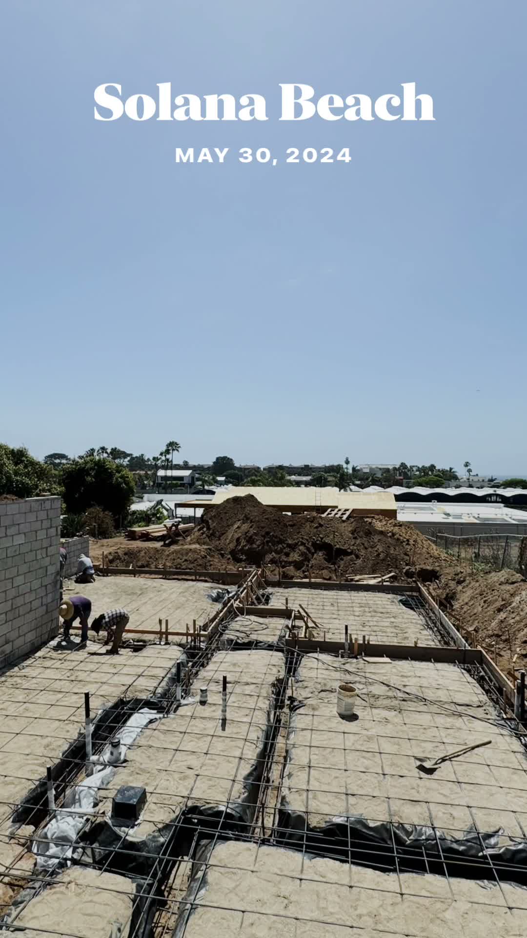 Foundation footings with steel rebar and workers on the Solana Beach job site, May 30 2024